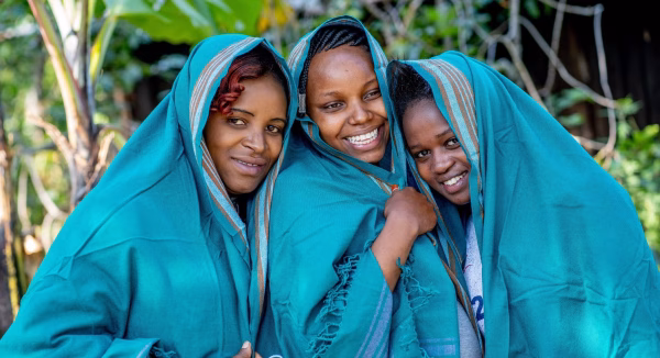 Three women wearing Team Mum kikoys, smiling. Participants of Team Mum.