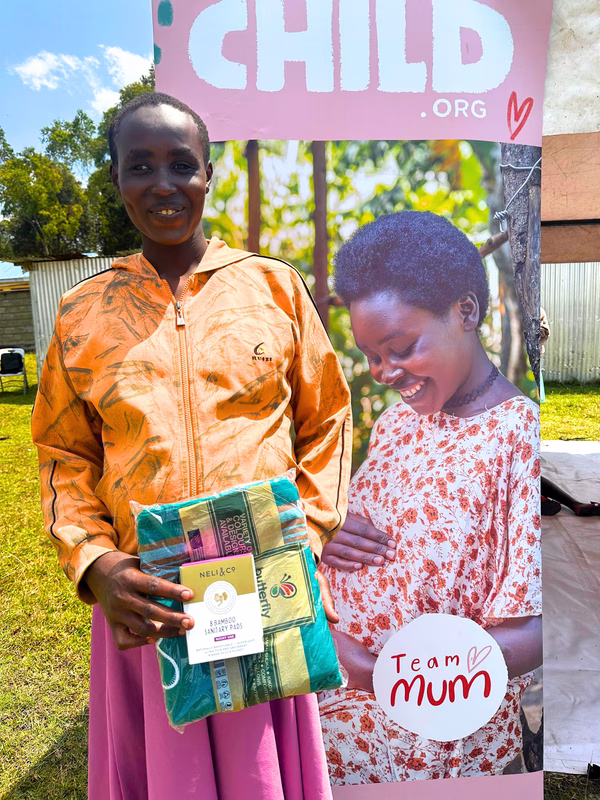 A young woman and recent graduate from a Pregnant Adolescent Group smiling and holding Neli & Co products